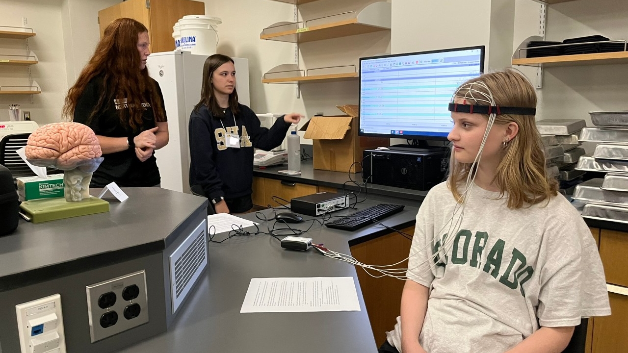 Students wear and test out EEG equipment, analyzing their data in 91's neuroscience research lab. 