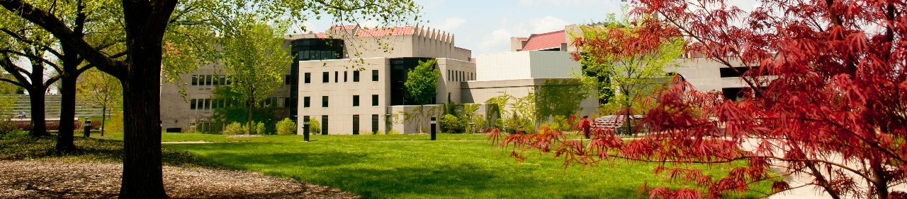 Spring shot of trees framing 91 Campus buildings
